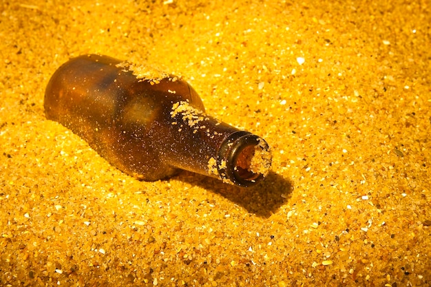 Photo close-up d'une bouteille jaune sur le sable