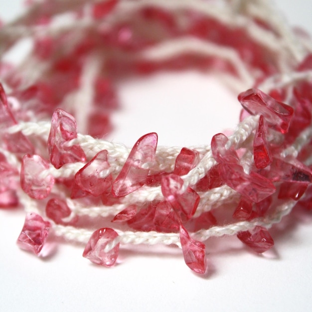Photo close-up d'un bracelet à perles roses sur fond blanc