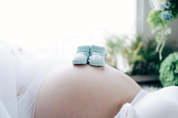 Close-up de chaussures de bébé sur le ventre