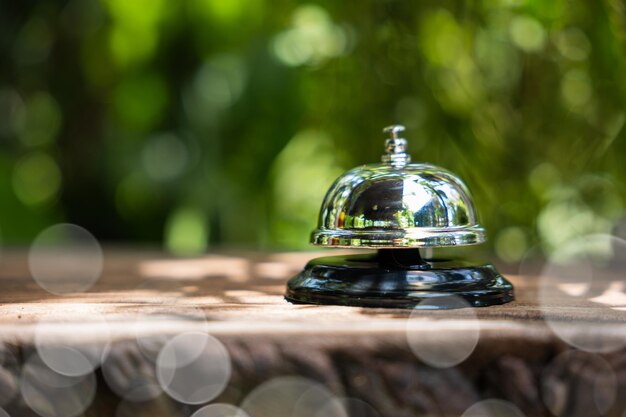 Close-up de la cloche du restaurant de service en argent sur le comptoir en bois