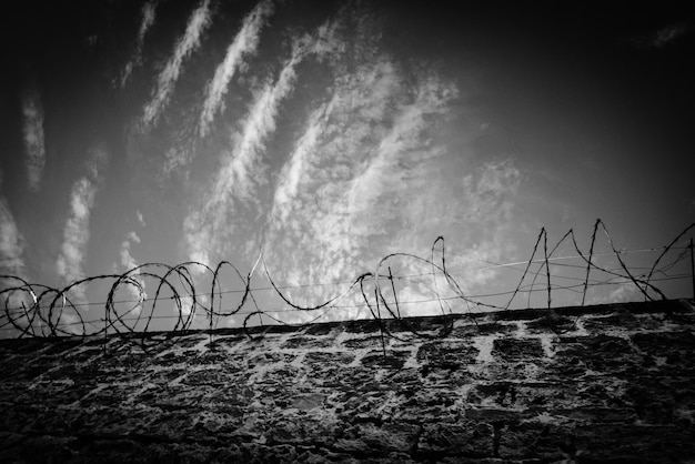 Photo close-up d'une clôture de fil de fer barbelé contre le ciel