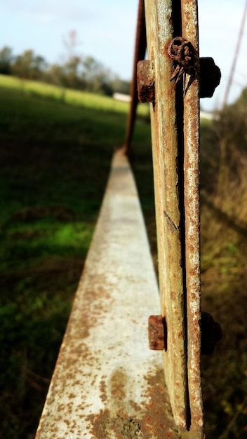 Close-up d'une clôture métallique rouillée sur le terrain