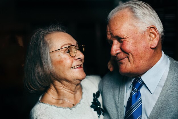 Photo close-up d'un couple d'aînés souriant dans la chambre noire