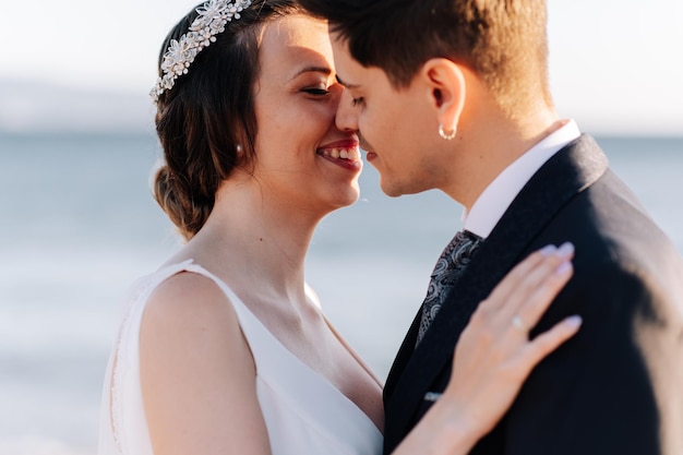 Close-up d'un couple de jeunes mariés s'embrassant sur la plage