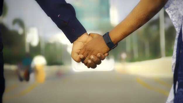 Photo close-up d'un couple se tenant par la main dans la rue