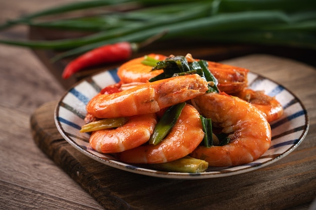 Close up de délicieuses crevettes poêlées maison dans une assiette sur une table en bois sombre