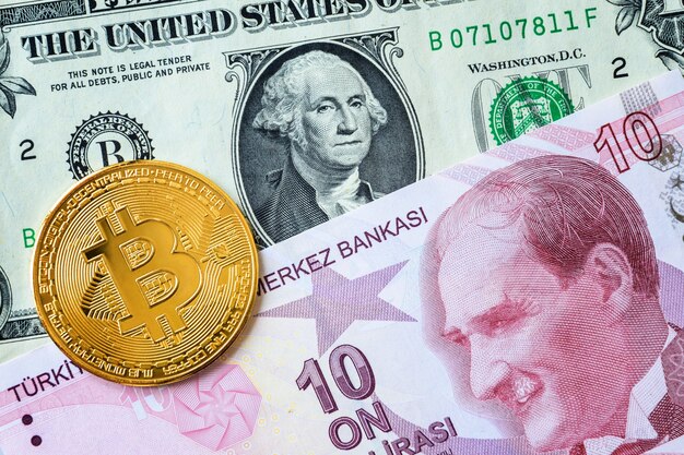 Close-up de dix livres turques et billets d'un dollar américain et une pièce d'or bitcoin