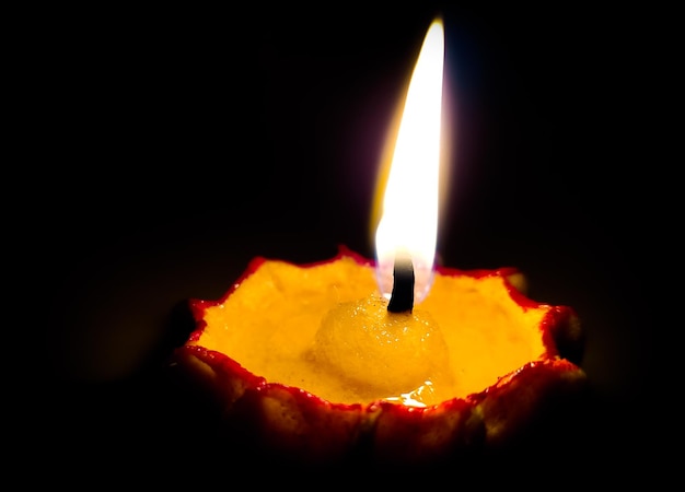 Photo close-up d'une diya éclairée dans une chambre noire