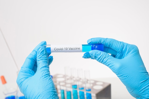 Close up docteur main tient le vaccin Covid-19 en laboratoire