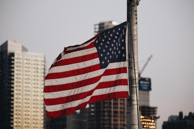 Photo close-up du drapeau américain contre les bâtiments de la ville