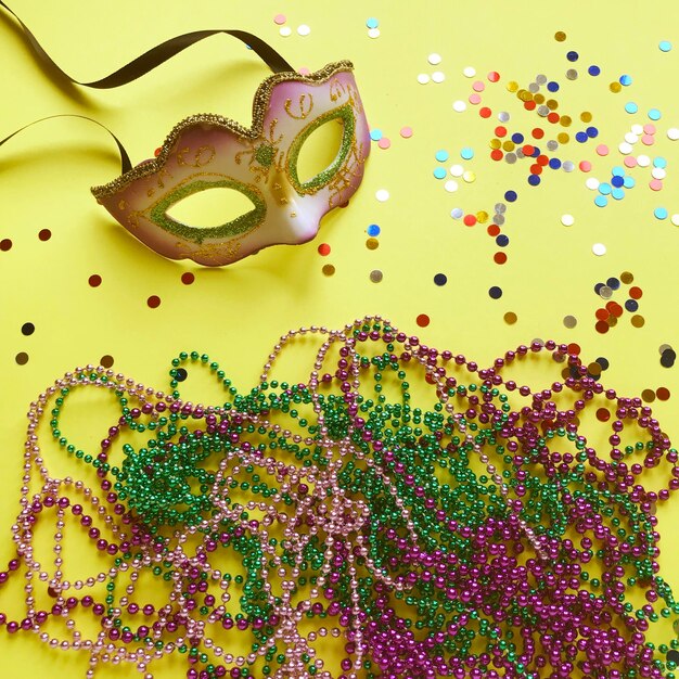 Photo close-up du masque et de la décoration sur fond jaune