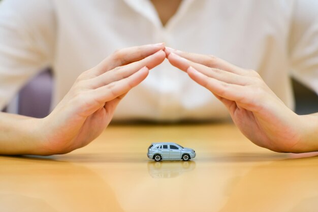 Close-up d'une femme d'affaires faisant des gestes sur une voiture jouet à son bureau au bureau