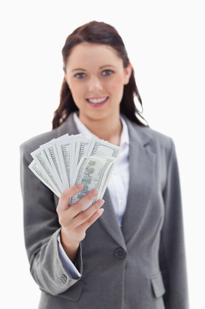 Close-up d&#39;une femme d&#39;affaires souriant et tenant beaucoup de billets de banque en dollars