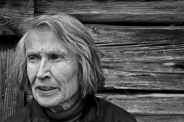 Photo close-up d'une femme âgée contre un mur en bois