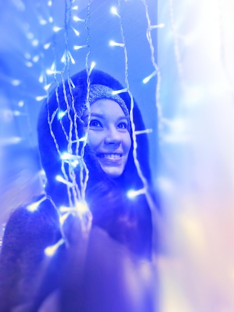 Photo close-up d'une femme debout devant l'éclairage éclairé à la maison