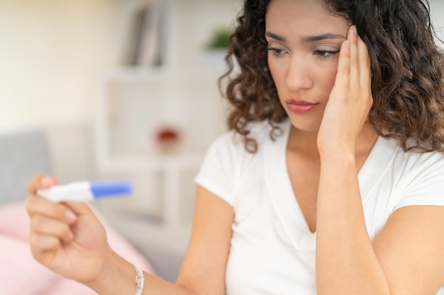 Photo close-up d'une femme désolée regardant les résultats d'un test de grossesse