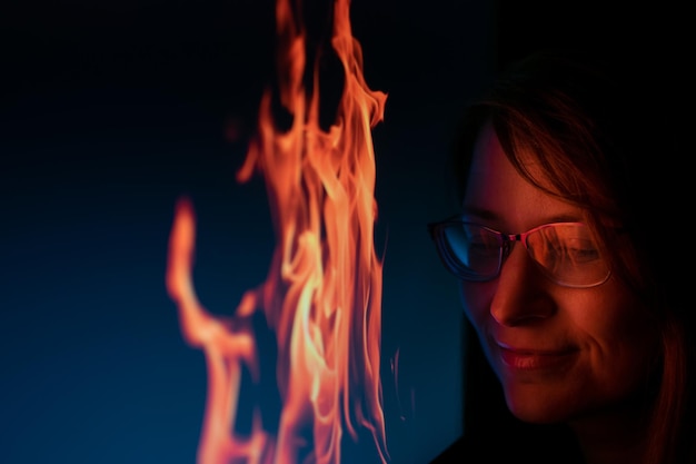 Photo close-up d'une femme avec du feu sur un fond noir