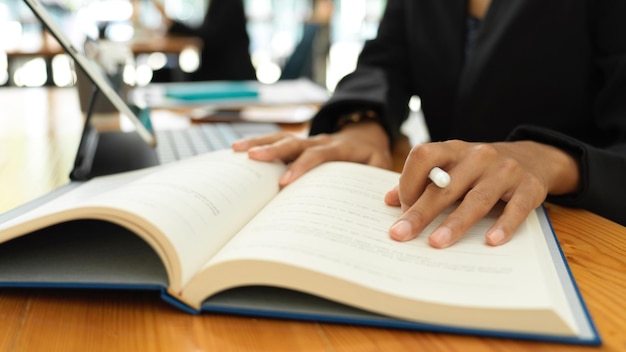 Photo close-up d'une femme lisant un livre sur une table