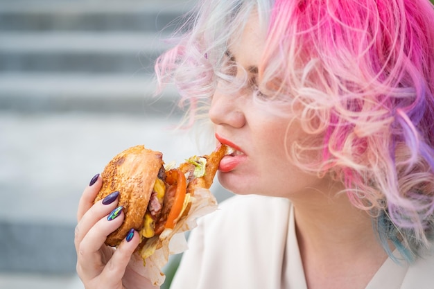 Close-up d'une femme mangeant un hamburger