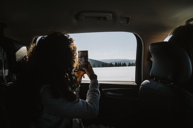 Close-up d'une femme photographiant à travers un smartphone contre le ciel