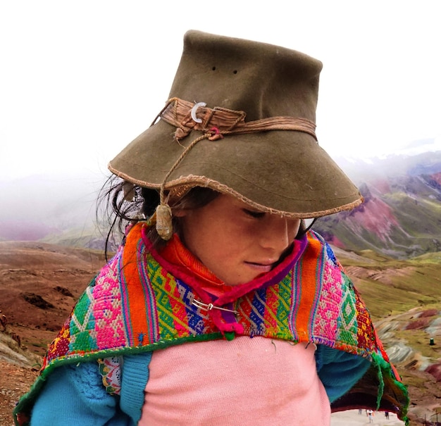 Photo close-up d'une femme portant un chapeau debout sur la montagne par temps brumeux