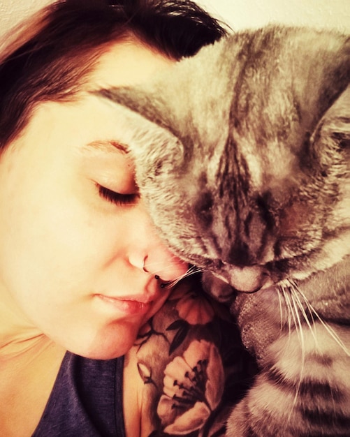 Photo close-up d'une femme qui dort avec un chat à la maison