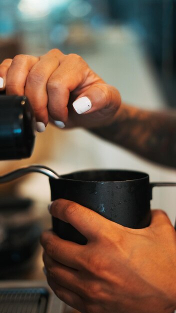 Photo close-up d'une femme remplissant un café dans une tasse
