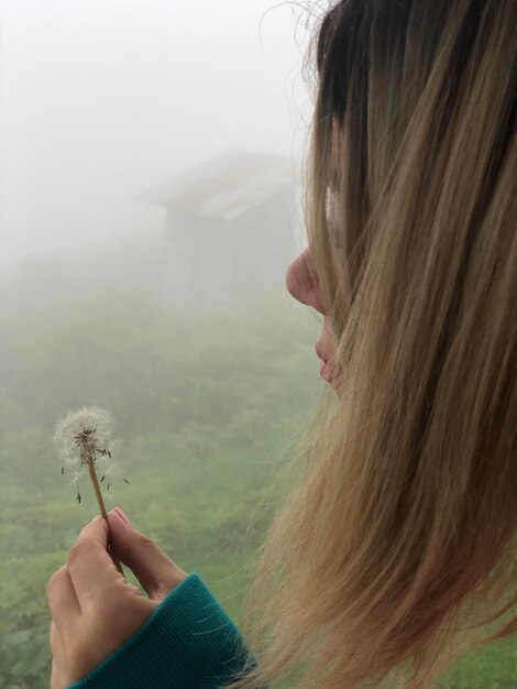 Photo close-up d'une femme tenant un pissenlit