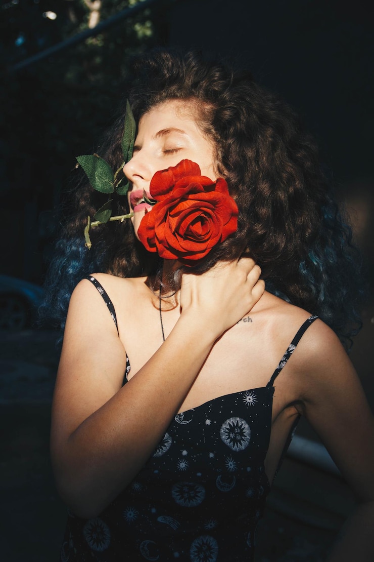 Photo close-up d'une femme tenant une rose rouge