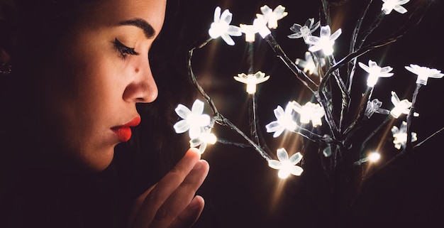 Photo close-up de femmes touchant des fils de lumière éclairés