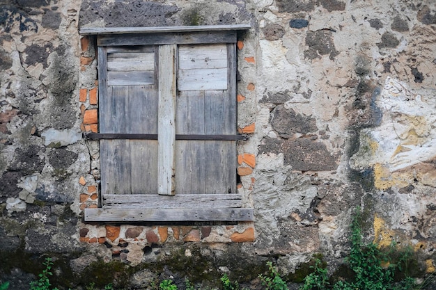 Photo close-up d'une fenêtre fermée au milieu d'un vieux mur