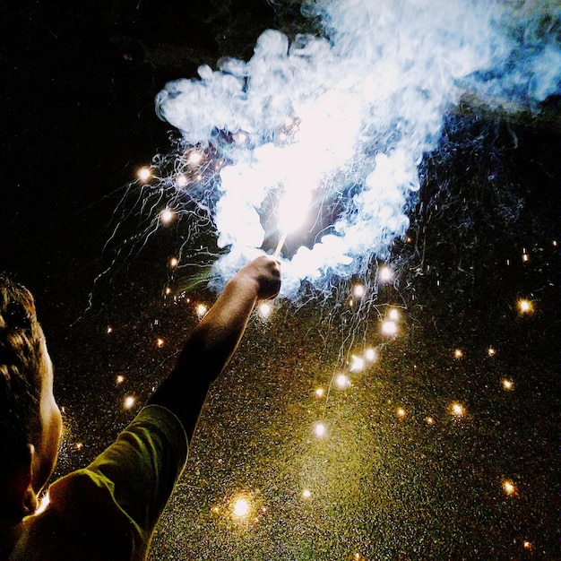 Photo close-up d'un feu d'artifice tenu à la main la nuit