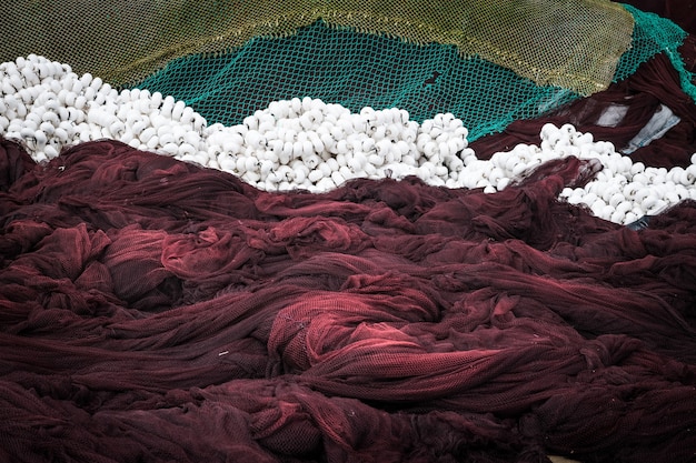 Close-up de filets de pêche vert et brun et des pièges séchant sur la côte galicienne au crépuscule