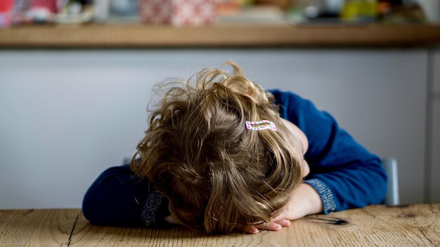 Close-up d'une fille appuyée sur la table à la maison