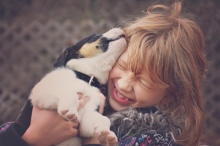 Photo close-up d'une fille avec un chiot dans le jardin
