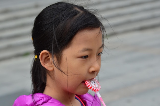 Close-up d'une fille qui mange des bonbons