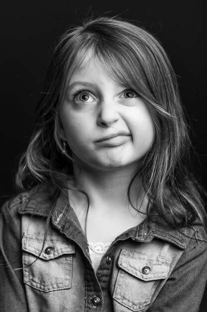 Photo close-up d'une fille réfléchie sur un fond noir