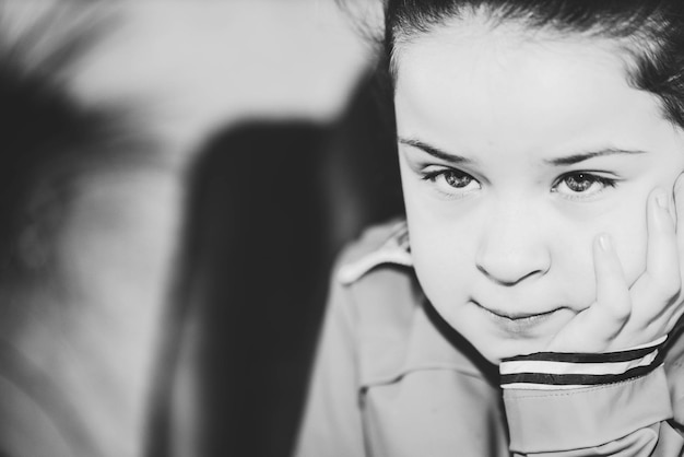 Photo close-up d'une fille réfléchie avec la main sur le menton