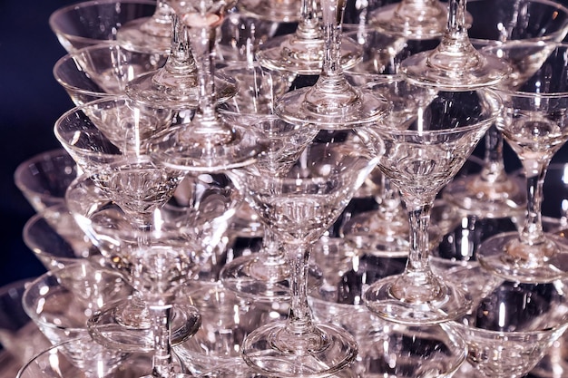 Close up fond festif plein cadre de verres vides pour champagne allumé la lumière à la fête de mariage formelle