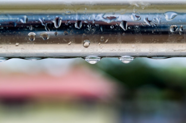 Photo close-up de gouttes d'eau sur verre contre le ciel pendant la saison des pluies