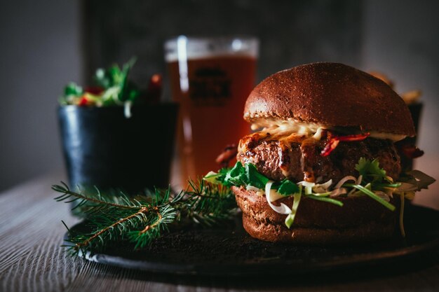 Photo close-up d'un hamburger avec un verre de bière sur la table