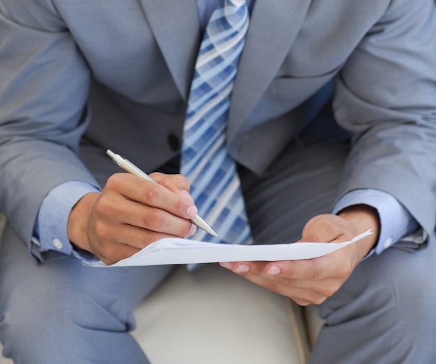 Close-up d&#39;un homme d&#39;affaires écrit sur un papier