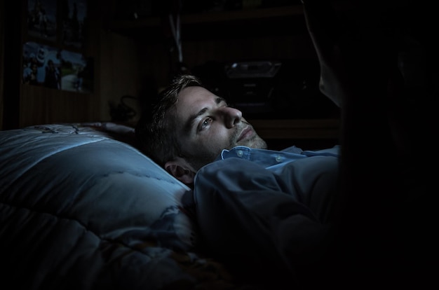 Close-up d'un homme allongé sur le lit la nuit