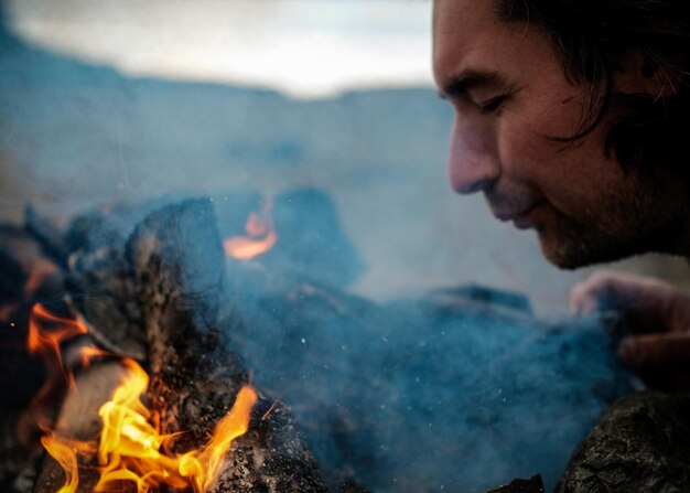 Photo close-up d'un homme brûlant un feu de camp à l'extérieur