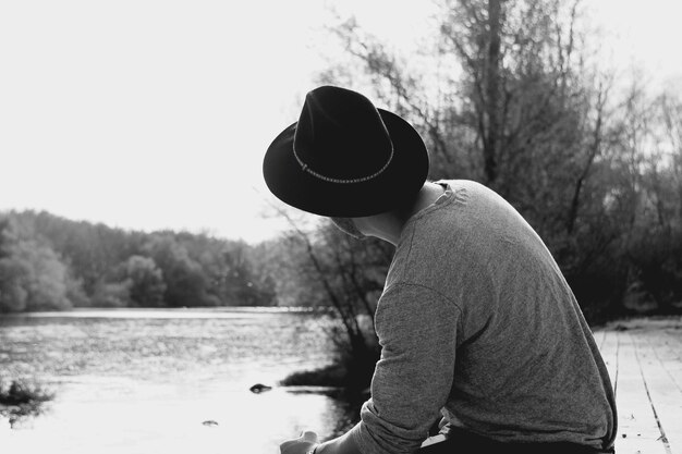 Photo close-up d'un homme debout au bord d'un lac contre le ciel