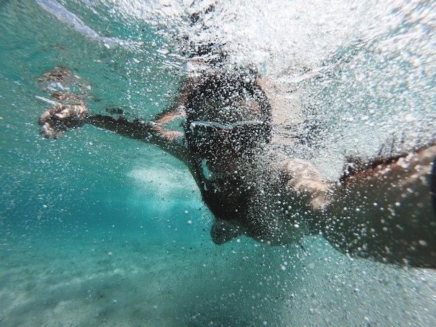 Close-up d'un homme nageant sous la mer