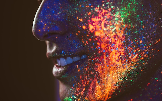Close-up d'un homme avec une peinture faciale multicolore