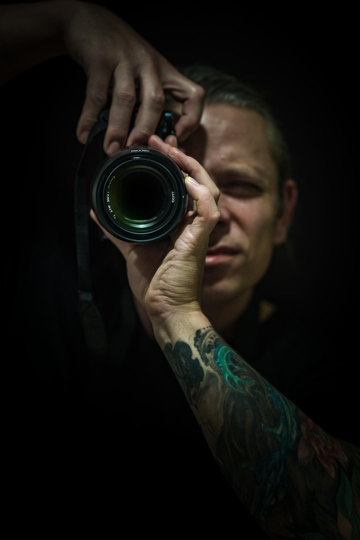 Photo close-up d'un homme photographiant avec un appareil photo numérique sur un fond noir