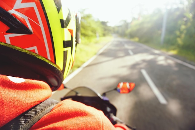 Close-up d'un homme portant un casque alors qu'il roule à moto sur la route