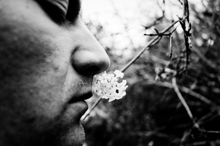 Photo close-up d'un homme qui sent les fleurs dans le jardin